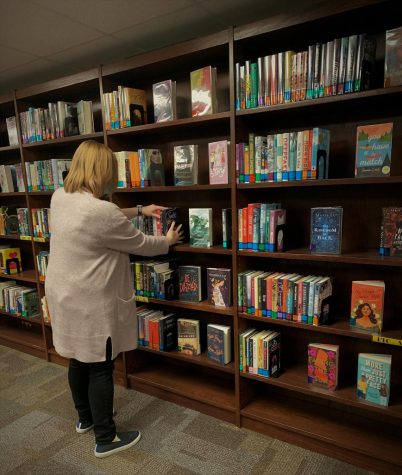 Boswell Librarian Nicole Graham shelves books in the library. Graham is one of several Bos staff members concerned about bans on certain books in neighboring school districts.